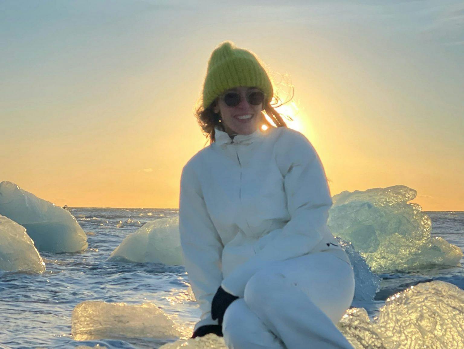 Photo of Giorgia Alimenti sitting on ice in front of a setting sun.