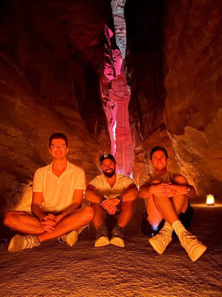Photo of Alvaro Luna with friends sitting on the ground in a narrow canyon.