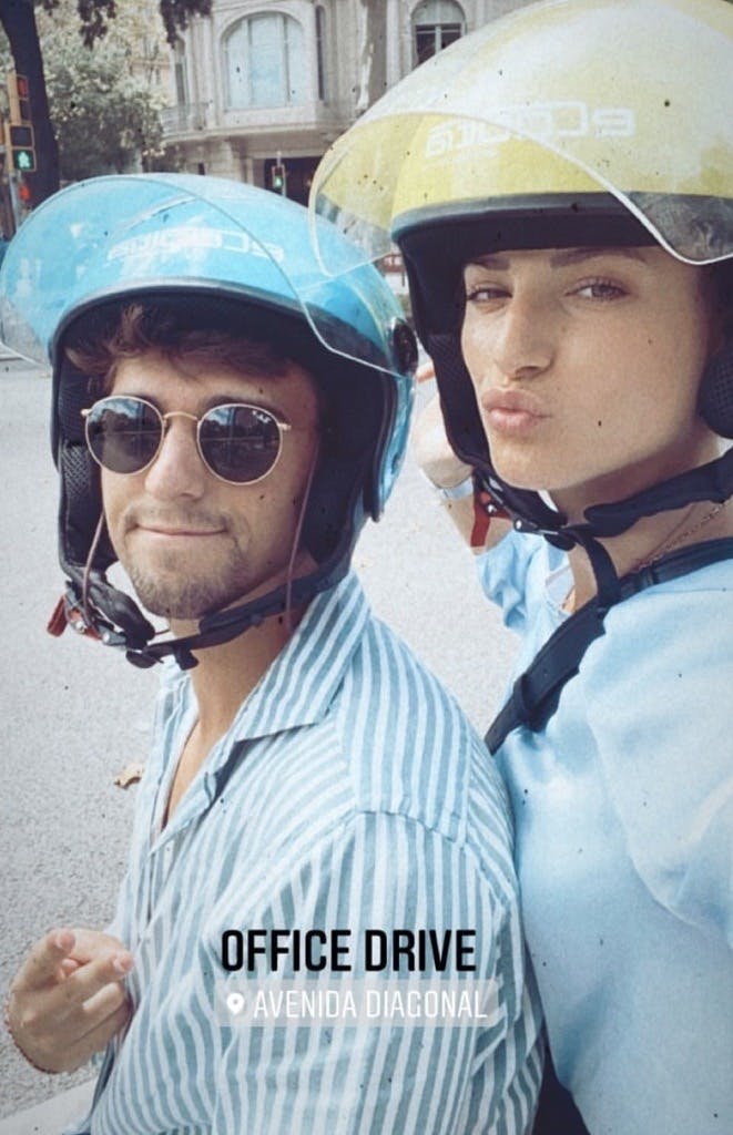 Photo of two people wearing motorcycle helmets, out for a ride.